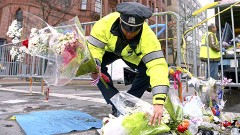 Un policía acomoda los objetos dejados en la línea de meta del Maratón de Boston, luego de los bombazos de la semana pasada.