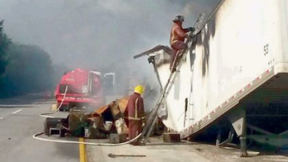 De esta manera, los bomberos de Cancún sofocaron las llamas de la caja del tráiler, que se incendió ayer en la autopista.